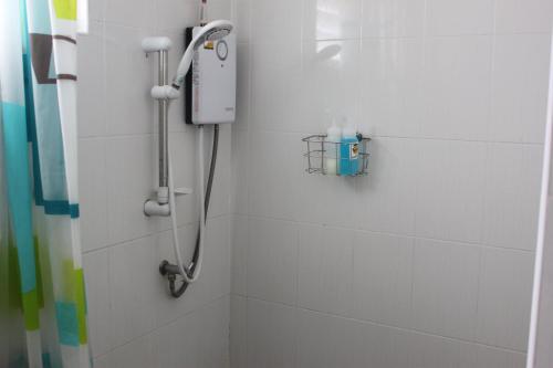 a shower in a white bathroom with a shower at The Chiang Mai Walkers in Chiang Mai