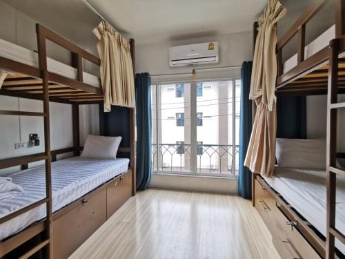 a room with two bunk beds and a window at The Chiang Mai Walkers in Chiang Mai