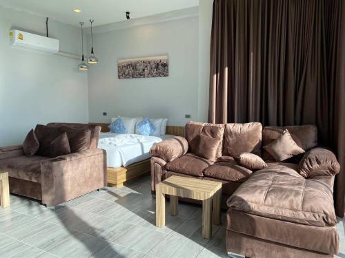 a living room with a couch and a bed at Belong Jin The Dam Hotel And Resort in Ban Pha Saeng Lang