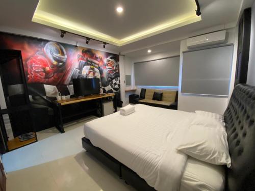 a bedroom with a white bed and a painting on the wall at น่านลอฟท์รูมแอร์พอร์ต in Nan