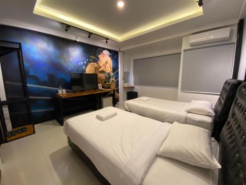 a room with two beds and a tv on the wall at น่านลอฟท์รูมแอร์พอร์ต in Nan