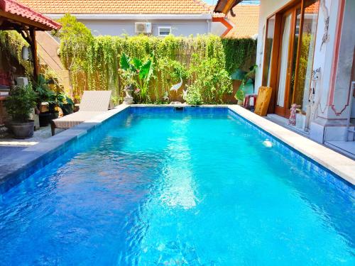 a swimming pool with blue water in a backyard at G Saskara Homestay in Sanur