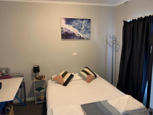 a bedroom with a bed and a desk and a window at Hello Adelaide Motel and Apartments in Adelaide