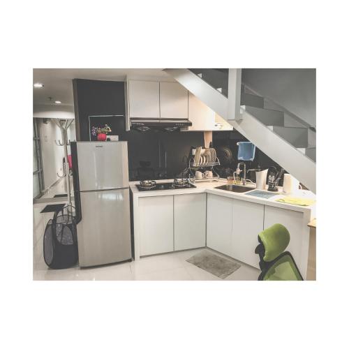 バヤンレパスにあるThe ceo suites by Zenbnbのキッチン(白いキャビネット、冷蔵庫付)