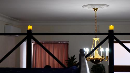 a chandelier with two candles in a living room at Затишні апартаменти, Дерибасівська in Odesa