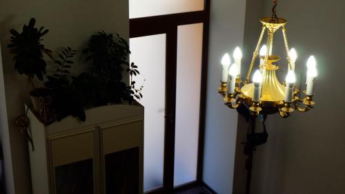 a chandelier in a room with a door and a mirror at Затишні апартаменти, Дерибасівська in Odesa