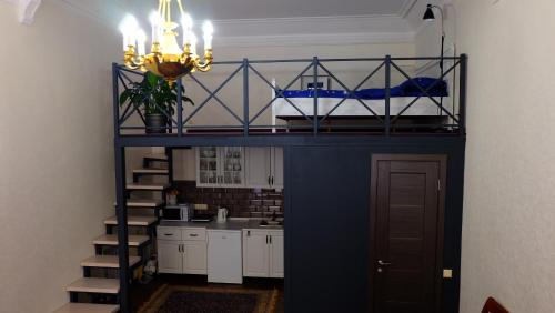 a blue bunk bed in a room with a kitchen at Затишні апартаменти, Дерибасівська in Odesa