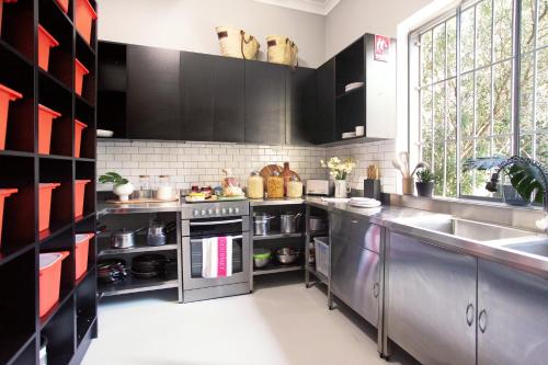 uma cozinha com armários pretos e electrodomésticos de aço inoxidável em Coogee Beach House em Sydney