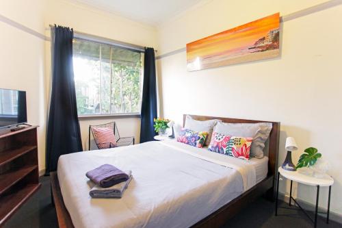 Un dormitorio con una cama grande y una ventana en Coogee Beach House, en Sídney