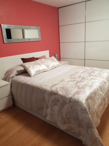 1 dormitorio con 1 cama grande y pared roja en Apartamento Puerto de la Cruz, en Puerto de la Cruz
