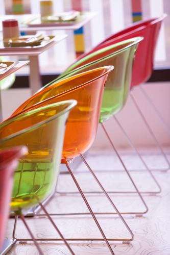 a row of colorful chairs sitting in a restaurant at ibis Styles Bordeaux Saint Médard in Saint-Médard-en-Jalles
