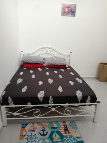 łóżko z czarno-białą kołdrą w pokoju w obiekcie Ros Residence w mieście Ayer Keroh