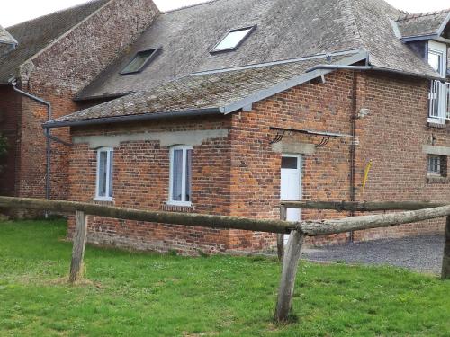 a brick house with a wooden fence in front of it at LE CHARME D OGNES in Ognes