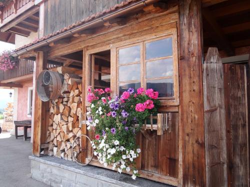 a window of a wooden building with flowers on it at Beim Haxenwirt in Immenstadt im Allgäu
