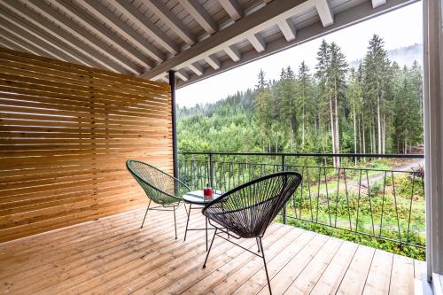 a patio with two chairs and a table on a deck at stuub langenbach in Titisee-Neustadt