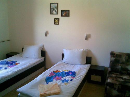 a room with two beds with towels and pictures on the wall at х-л,р-тШИПКА на връх ШИПКА in Shipka