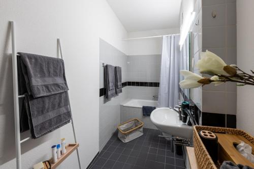 ein Badezimmer mit einem Waschbecken, einem WC und einer Badewanne in der Unterkunft OfficeWerft Business-Apartments in Luzern