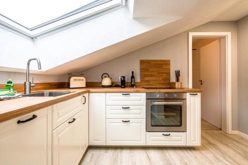 a kitchen with white cabinets and a sink at stuub langenbach in Titisee-Neustadt