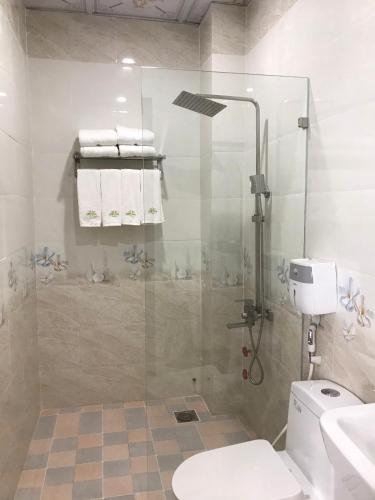 a bathroom with a shower with a toilet and a sink at Lucky Star Ho Tram Hotel & Restaurant in Ho Tram