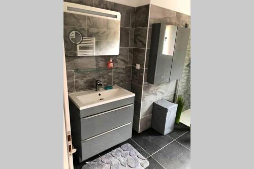 une salle de bain avec un lavabo et un miroir dans l'établissement Agréable Maison entre Bordeaux et le Bassin, à Saint-Jean-dʼIllac