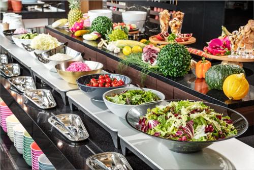a buffet line with bowls of vegetables and fruits at Villa Fontaine Grand Tokyo Ariake in Tokyo