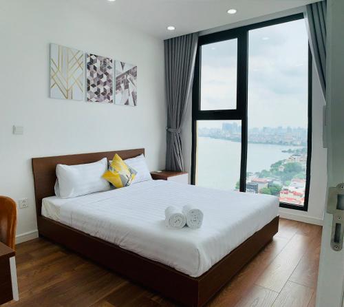 ein Schlafzimmer mit einem großen Bett mit zwei Handtüchern darauf in der Unterkunft Asahi Luxstay - D'el Dorado Apartment in Hanoi