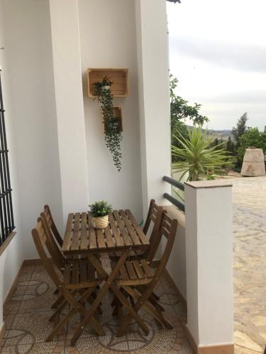 einen Holztisch und Stühle auf einer Veranda in der Unterkunft Casa Atardecer in Zahara de la Sierra