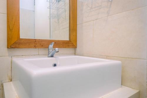 a white sink in a bathroom with a mirror at Modern Furnished @ 1BR Margonda Residence 1 Apartment By Travelio in Depok
