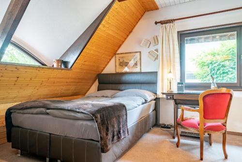 a bedroom with a bed and a desk and a chair at Apartment am Bullerbach Deister in Barsinghausen