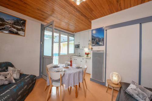 un salon avec une table et une cuisine dans l'établissement Studio Les Marmottes hypercentre de Cauterets, à Cauterets