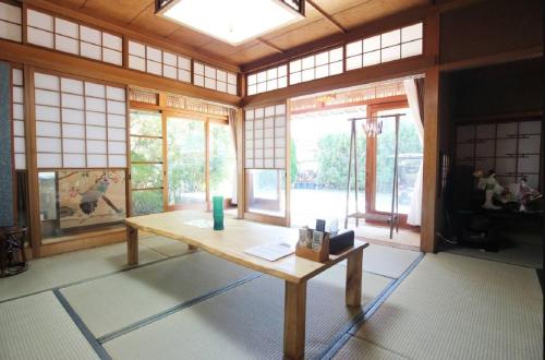a room with a table in a room with windows at Yadokari Osaka in Neyagawa