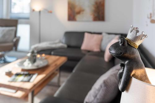 a toy dog wearing a crown sitting on a couch at Appartement "Froschkönig" - Oase am Haff in Garz-Usedom