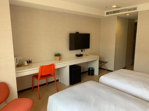 a room with a desk with a television and a bed at HATAGO+ THE ALLEY in Taipei