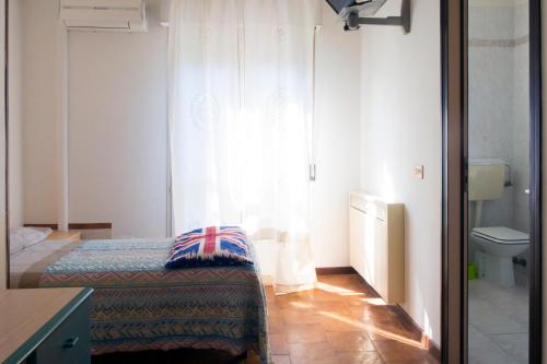 Dormitorio pequeño con cama y aseo en Hotel La Vela, en Castelnuovo Rangone
