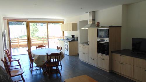 une cuisine avec une table et une salle à manger avec une télévision dans l'établissement Appartement 52m2 - Location vacances Vosges, à Belmont-sur-Buttant