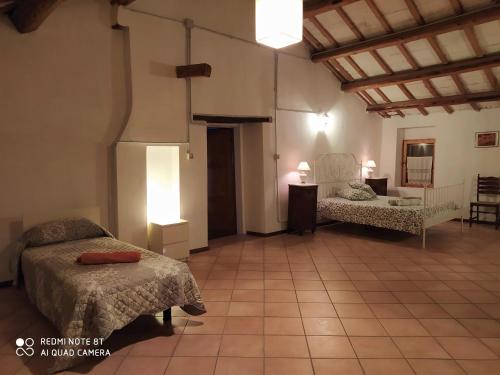 MombaroccioにあるLa casa delle Luneのベッド2台と椅子が備わる広い客室です。