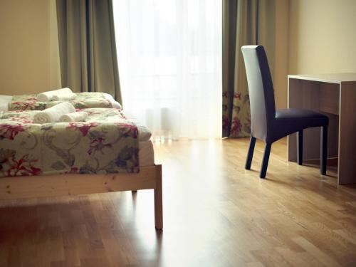 a bedroom with a bed and a chair and a desk at Kamanos in Utena