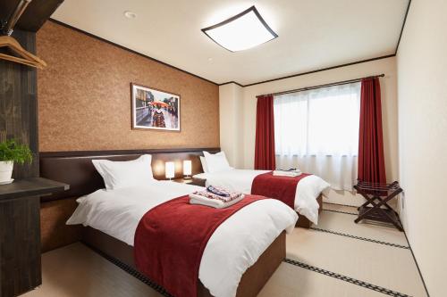 um quarto de hotel com duas camas e uma janela em The Address Akakura em Myoko