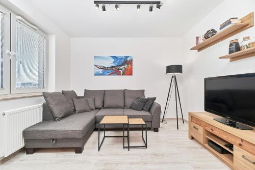 弗次瓦夫的住宿－Exclusive Apartments Tęczowa with underground PARKING by Renters，带沙发和平面电视的客厅