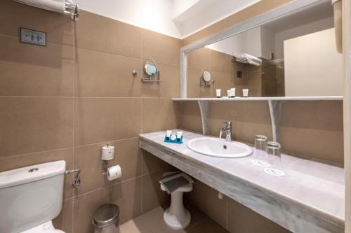 bagno con lavandino, servizi igienici e specchio di Skala Hotel a Skála