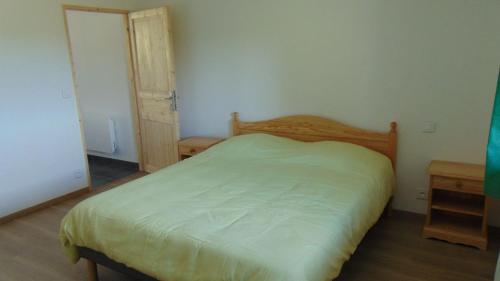 a bedroom with a bed and two wooden tables at Appartement 52m2 - Location vacances Vosges in Belmont-sur-Buttant