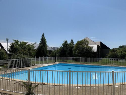 a swimming pool with a fence around it at Les Sables d'Or in Équemauville