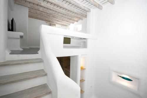 a white staircase in a room with white walls at 5 Traditional Suites in Livadi Astypalaias