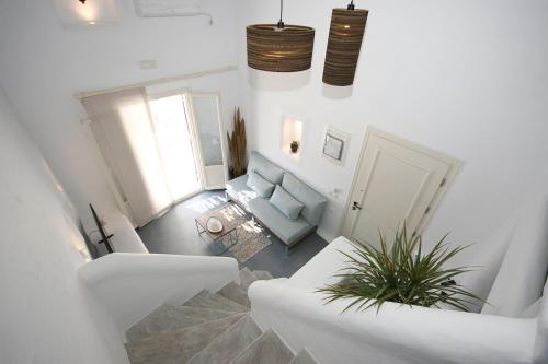a white living room with a couch and a chair at 5 Traditional Suites in Livadi Astypalaias