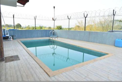 een zwembad met blauw water en een hek bij Killer Villa 3 BHK in Lonavala