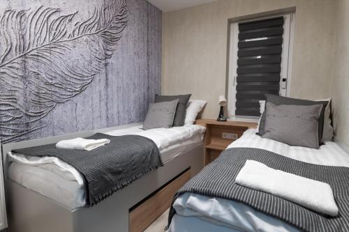 dos camas sentadas una al lado de la otra en una habitación en Manna Aparthotel, en Jászberény