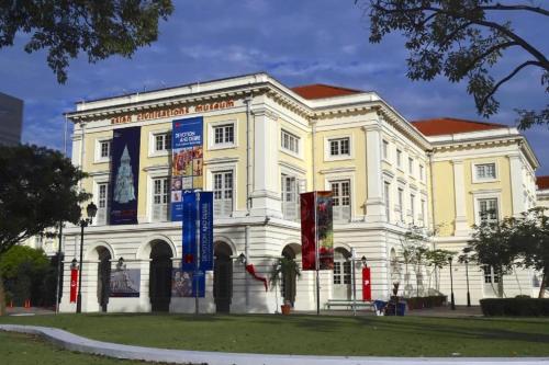 a white building with a sign in front of it at K Space Inn 14 in Singapore
