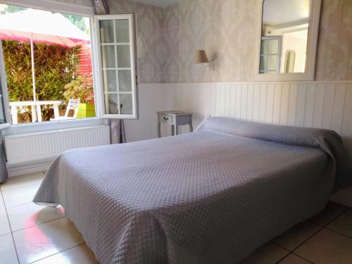 a bedroom with a bed with a mirror and a window at La Touille in Cénac-et-Saint-Julien