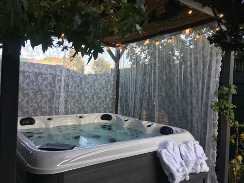 a hot tub in a backyard with a window at La Villa des Roses - Suite & Spa in Lys-lez Lannoy