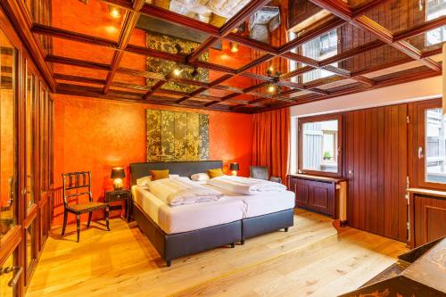 sypialnia z dużym łóżkiem i pomarańczowymi ścianami w obiekcie Appartement Seefeld Tirol - Luxusappartement Birkenwald w mieście Seefeld in Tirol